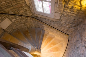 Eine steinerne Wendeltreppe mit einem Fenster oben.