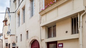 A historic building with a red door, a balcony with flowers, and a cobblestone street. - BSH - Beaune Allerey - Parking included (Beaune)
