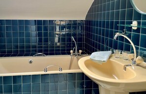 Een bad/douchecombinatie, een haardroger, handdoeken, zeep