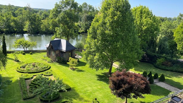 Ein gepflegter Garten mit einem Pavillon, einem See und einer Grillgegend.