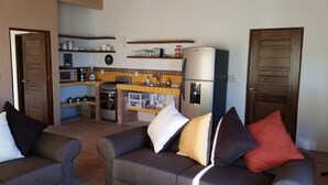 A compact living space with a kitchenette, two sofas with cushions, and a refrigerator. - 1 Bedroom Apartment in Flat Area Near the Beach and Zocalo  (Bucerías)