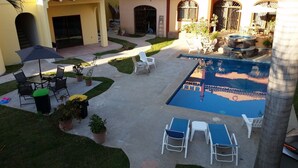 A courtyard with a swimming pool, outdoor seating, and potted plants. - 1 Bedroom Apartment in Flat Area Near the Beach and Zocalo  (Bucerías)