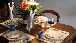 A dining table set with plates, cutlery, wine glasses, and a vase with flowers. - Private Courtyard and Pool, close to Carcassonne and Mediterranean Beaches (Argeliers)