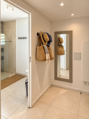 A bathroom with a shower, a toilet, and a mirror.