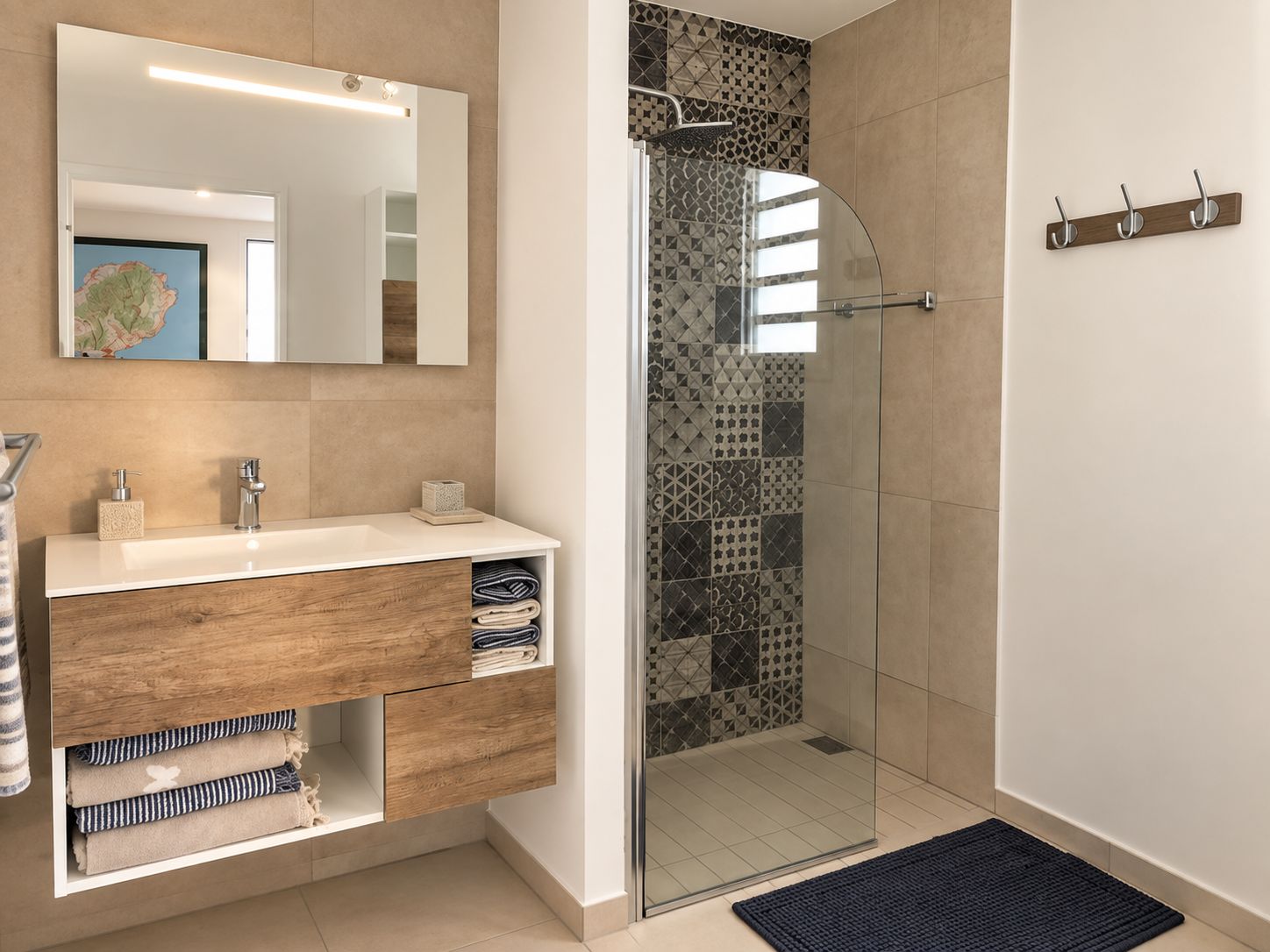 Un baño moderno con cabina de ducha de vidrio, tocador de madera y un espejo grande.