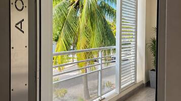 Een modern interieur met een balkon, met uitzicht op palmbomen en een heldere lucht.