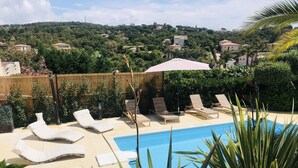 Un espace piscine avec des chaises longues et une clôture en bois.