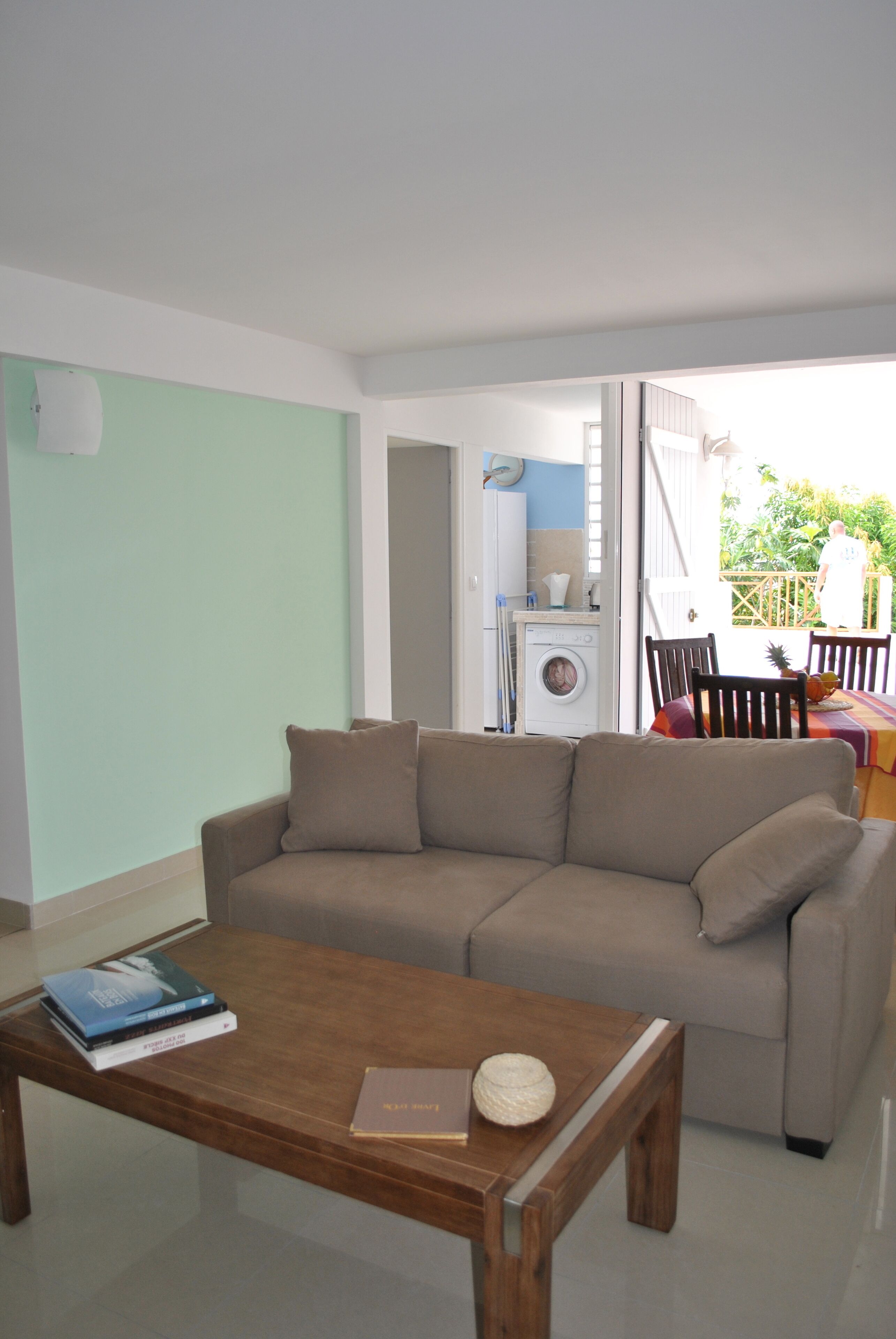 A living room with a sofa, a coffee table, and a dining area with chairs and a table.