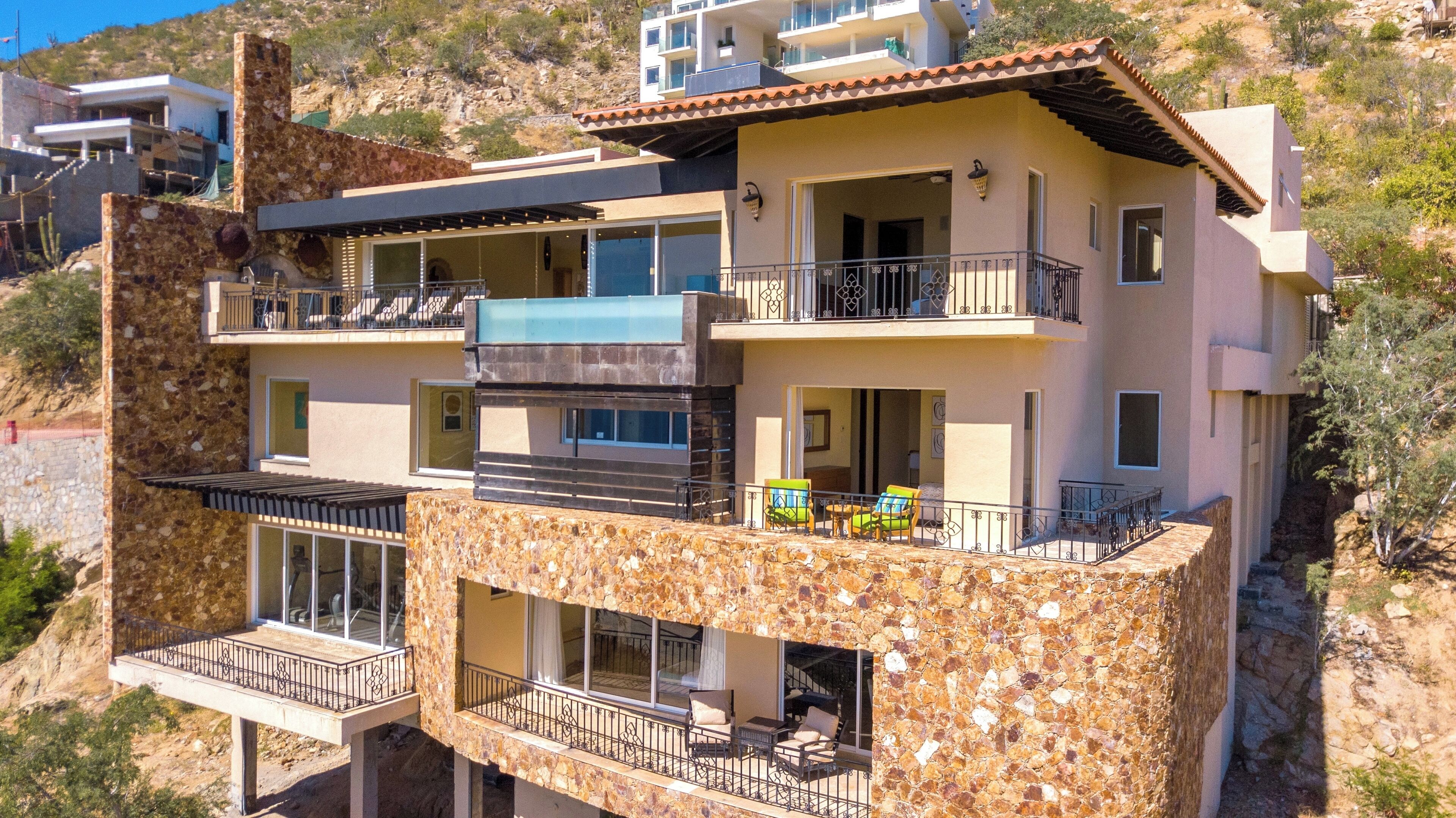 A multi-story building with balconies, large windows, and a stone facade.