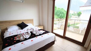Habitación de hotel con cama, ventana grande y vistas a zonas verdes.