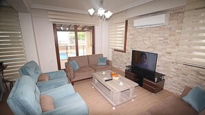 Una sala de estar con un sofá, una mesa de centro, un televisor y una chimenea.