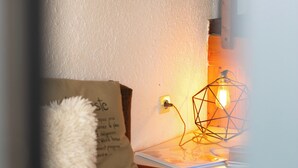 A cozy room with a brown sofa, a white fluffy pillow, a geometric light fixture, and a wall socket. - VALLEY RIO cottage style 2/6 persons (Le Chambon-Sur-Lignon)