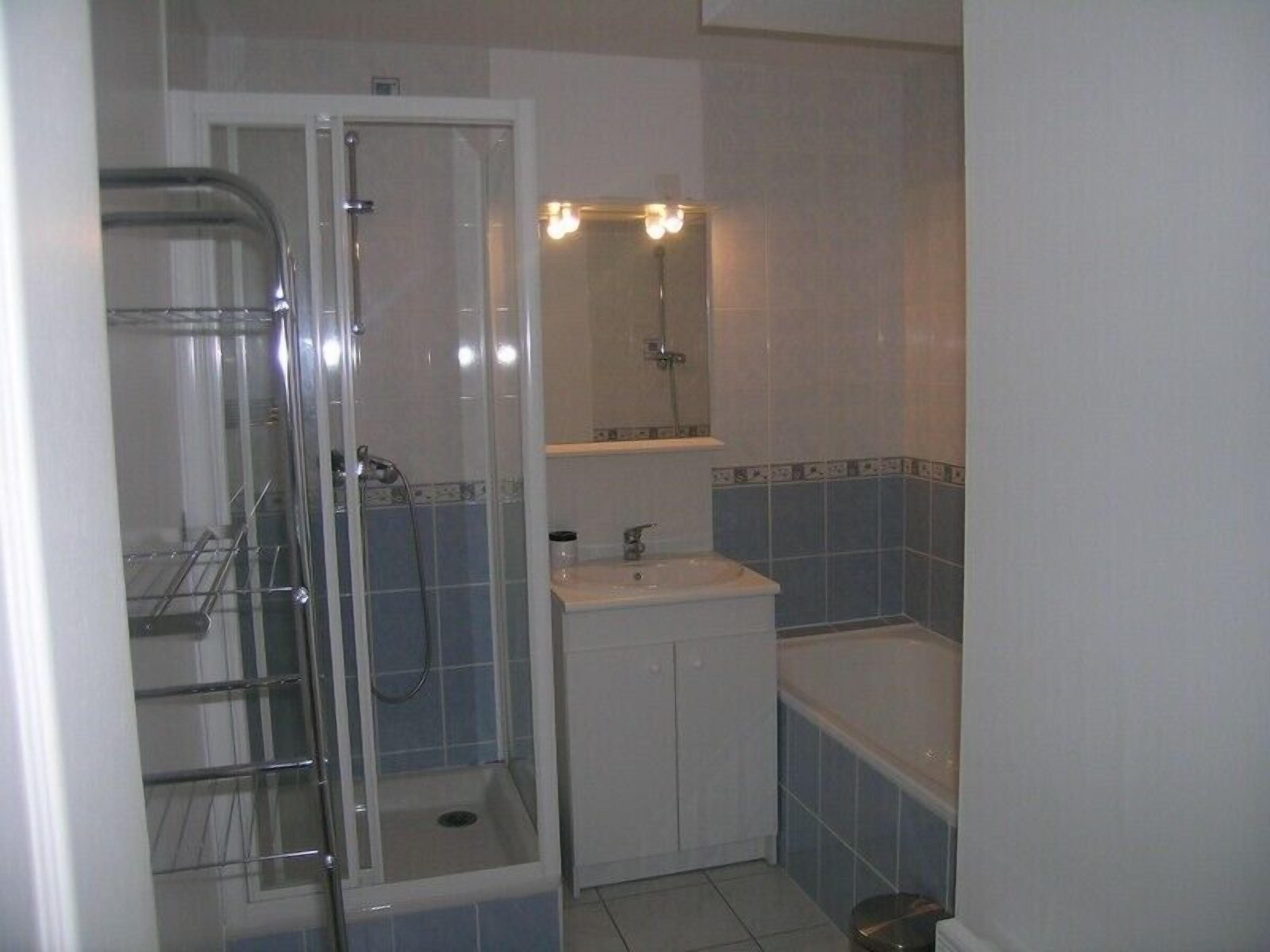 Salle de bains avec douche et baignoire.