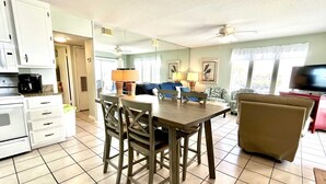 Una cocina compacta con comedor, un sofá y una televisión.