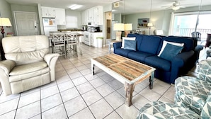 Un espacio habitable compacto con kitchenette, zona de comedor, sofá y mesa de centro.