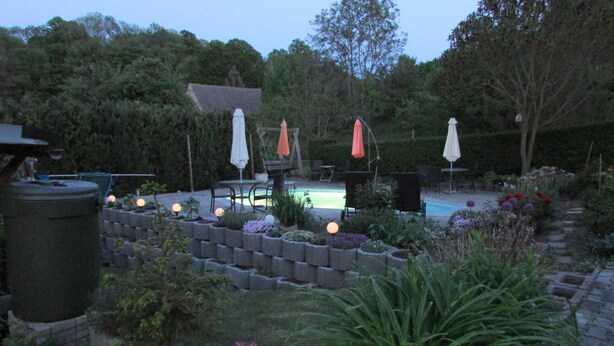 A garden with a pool, outdoor furniture, and a variety of plants. - NoOaks (Meissen)