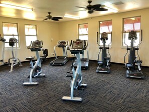 A gym with stationary bikes, treadmills, and elliptical machines. - Luxury condo with central A/C and golf and ocean views (Koloa)