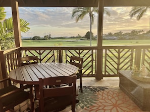 Relax in a serene outdoor seating area overlooking the golf course, featuring a table, chairs, and a sofa.