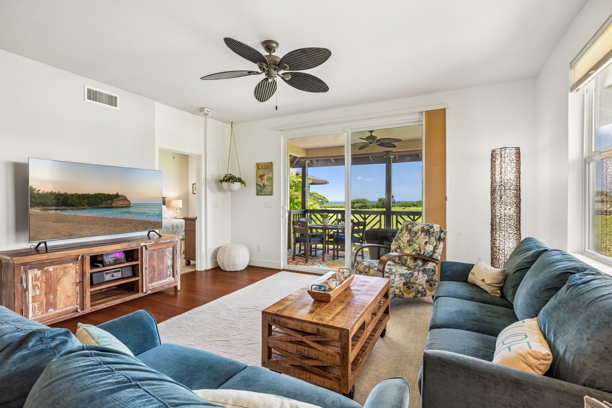 A modern living room with a television, wooden entertainment unit, and a large sofa.