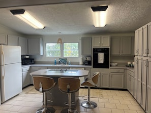 Enjoy dining or socializing at the central island with bar stools in this well-equipped kitchen.