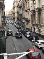 Una veduta di strada con auto parcheggiate e edifici.
