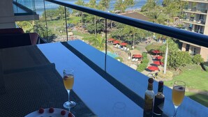 A balcony with a view of the ocean and resort amenities. - Ocean View Upgraded Top Fl HOKU711 Shaded Lanai see condo comparison chart  (Lahaina)