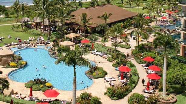 A resort with a large pool, palm trees, and a view of the ocean. - Ocean View Upgraded Top Fl HOKU711 Shaded Lanai see condo comparison chart  (Lahaina)