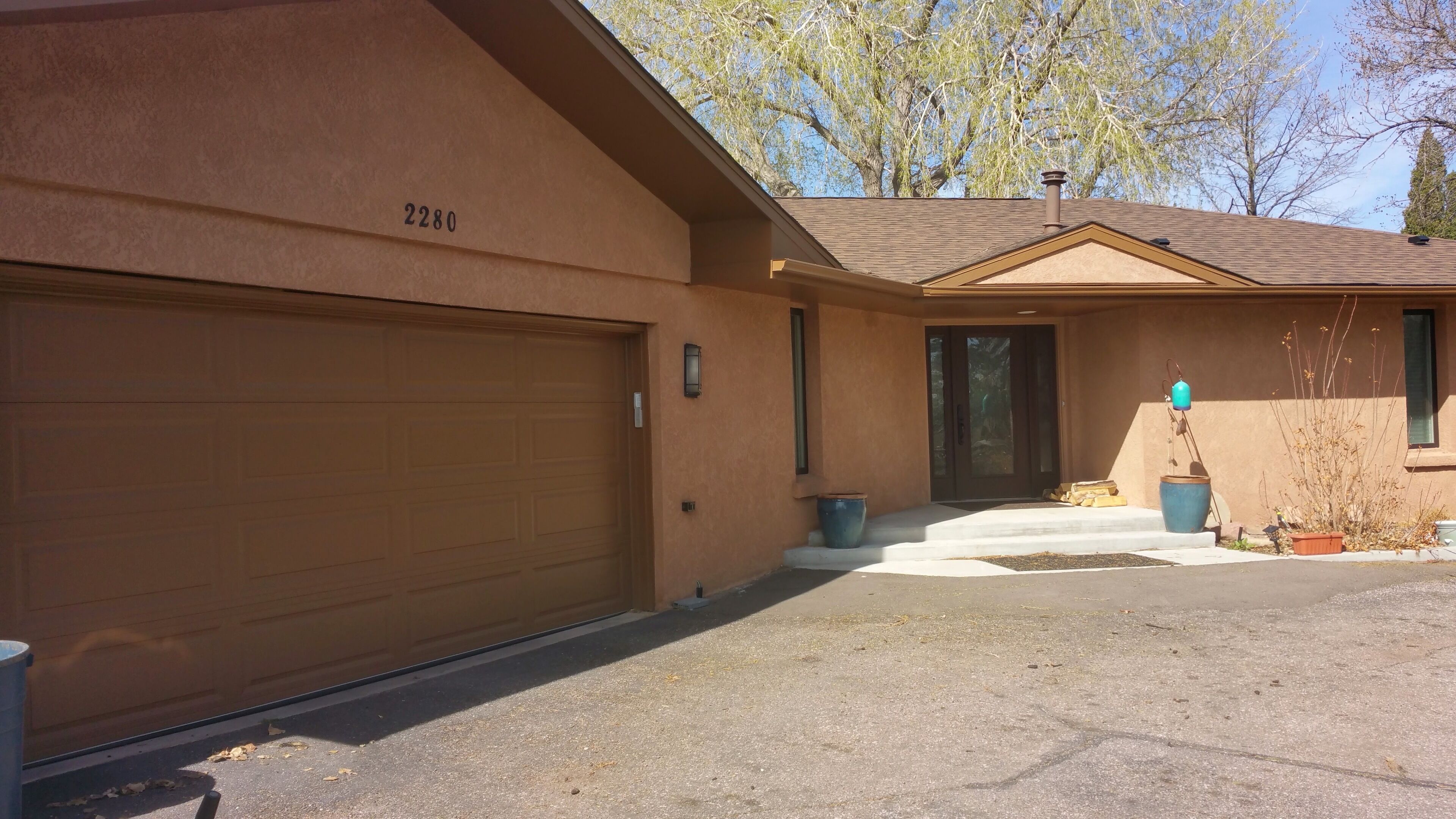 A two-story house with a garage, a front door, and a small porch area.