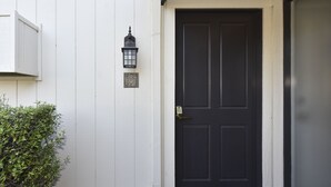 A black door with a white doorbell and a mailbox on the white wall. - Getaway Suite at Silverado in Napa (Napa)