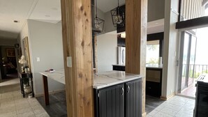 Une cuisine spacieuse agrémentée d’éléments en bois, dotée d’un îlot central et offrant une vue sur l’extérieur.