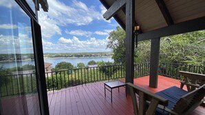 Une terrasse en bois avec un plancher rouge, un banc et une table.