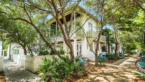 A white building with a porch and a bicycle parked outside. - Sandy Souls Cottage & CH - NEWLY RENOVATED! GULF VIEWS! ACCESS TO FITNESS/TENNIS (Rosemary Beach)