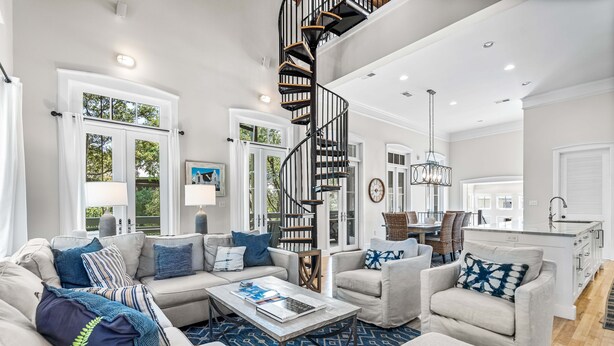 A spacious living room with a modern staircase, a dining area, and a kitchen. - Sandy Souls Cottage & CH - NEWLY RENOVATED! GULF VIEWS! ACCESS TO FITNESS/TENNIS (Rosemary Beach)