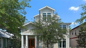 A two-story house with a central entrance, a small porch, and a white picket fence. - 5-bedroom Home just 4.5 min walk to Dedicated Private Beach & 2 community pools (Santa Rosa Beach)