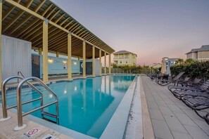 Relax by the rectangular pool surrounded by a tiled deck and lounge chairs.