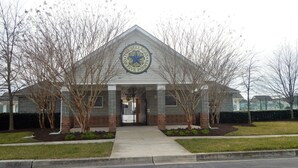 A building with a triangular roof and a circular emblem on the front.