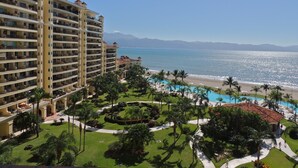 Un complexe hôtelier doté de nombreux balcons, d’une piscine et offrant une vue sur la plage.
