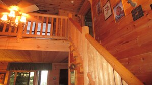 A wooden interior with a staircase, wooden walls, and a ceiling fan. - Entire cabin for rent, 30-day minimum stay.   (Clayton)
