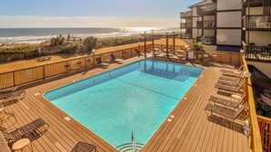 Un espace piscine offrant une vue sur la plage et l’océan.