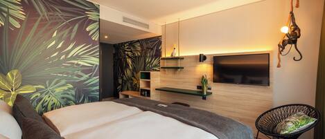 Un dormitorio moderno con cama, una silla, un televisor y una pared con un mural de plantas.