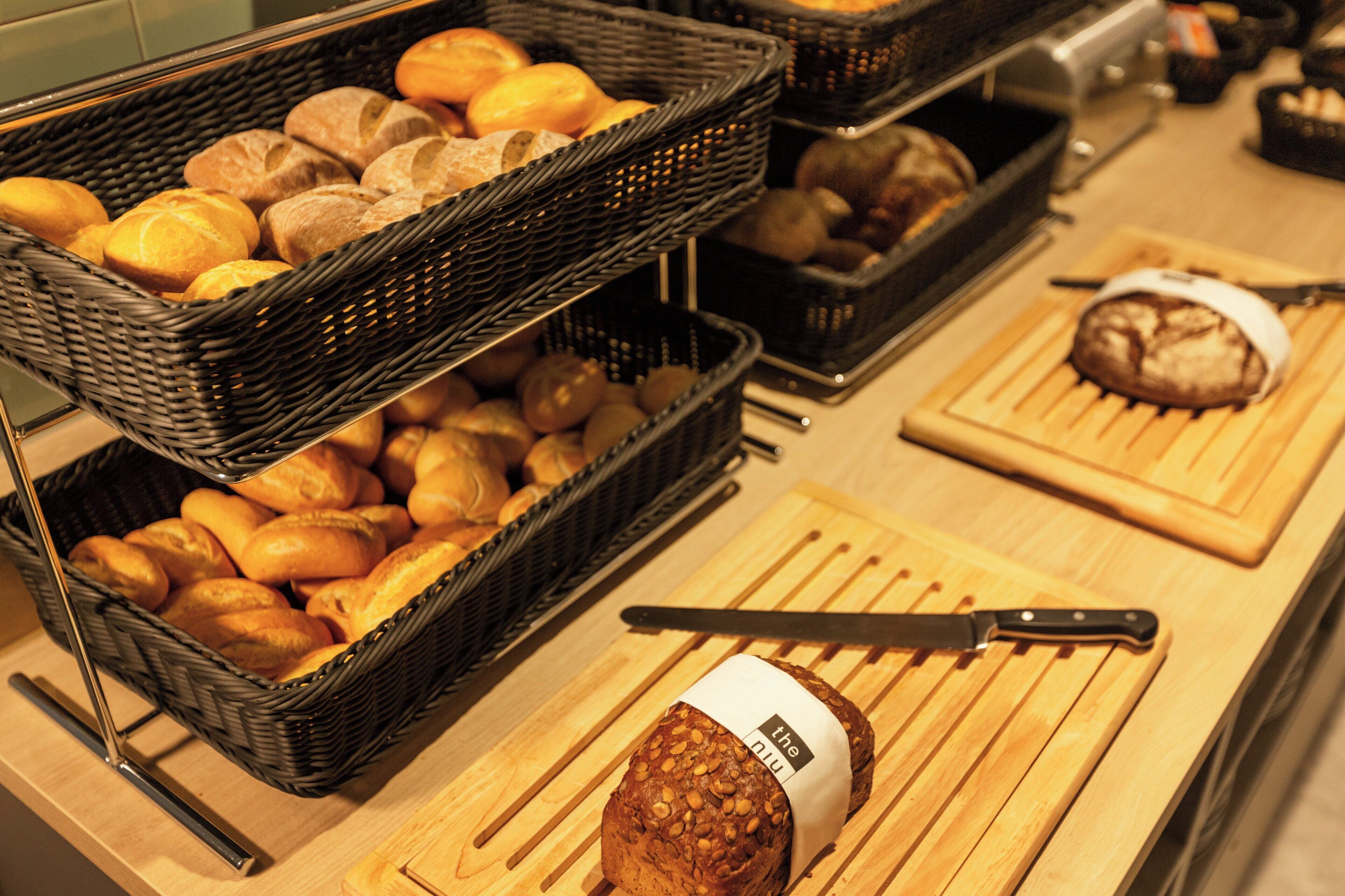 A bakery display with various breads and pastries in baskets.