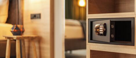 A wooden cabinet with a safe, a small stool, and a lamp.