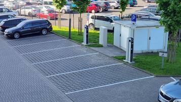 A parking lot with multiple cars, a small portable building, and a disabled parking sign.