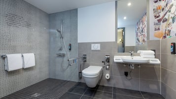 A modern bathroom with a shower, toilet, and sink.