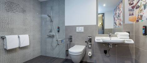 A modern bathroom with a shower, toilet, and sink.