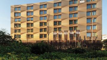 Ein modernes Hotelgebäude mit einer geometrischen Fassade und zahlreichen Fenstern.