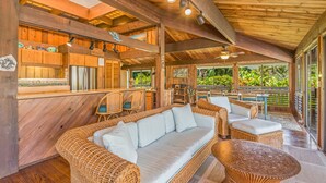 A wooden interior with wicker furniture, a bar area, and large windows.