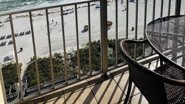 Ein Balkon mit Blick auf Strand und Meer.