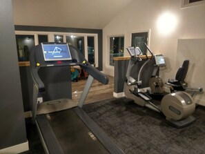A home gym with treadmills and elliptical machines.