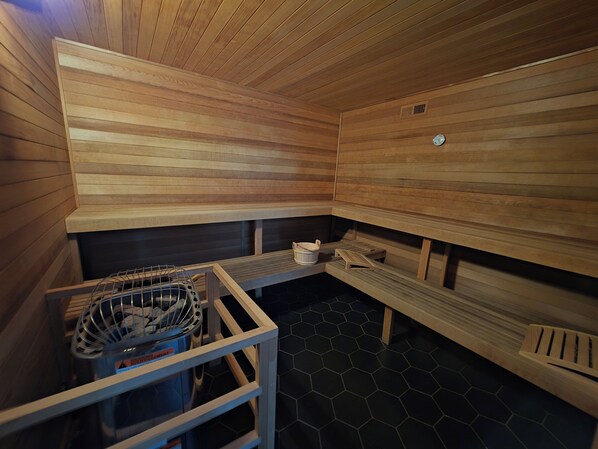 A sauna with wooden benches, a metal bench, and a tiled floor. - 300 steps to the slopes, Cozy Split-Level Loft, Fireplace, Hot Tubs, Free Bus (Steamboat Springs)